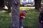 Behind a tree with her apple