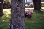 Maeve behind a tree